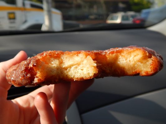 The same apple fritter torn open, showing the airy interior and cinnamon swirl